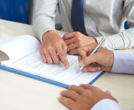 two men reviewing and signing paperwork