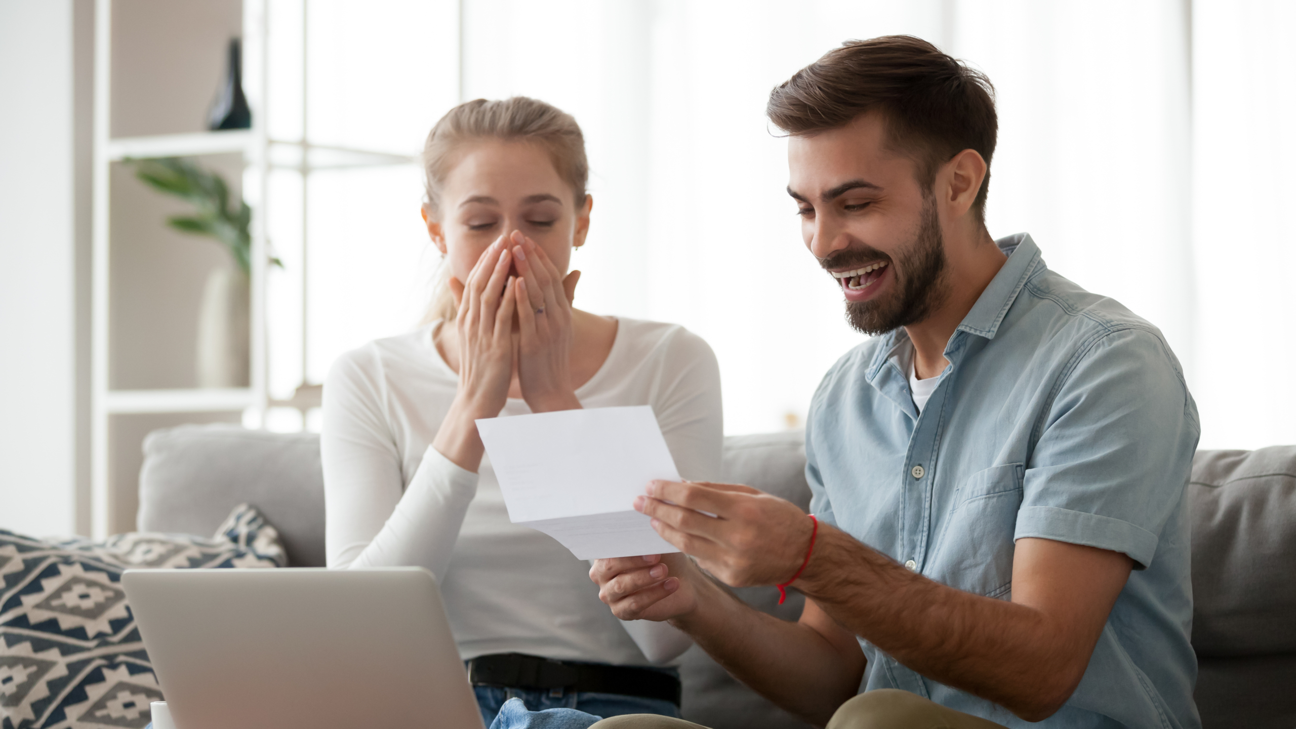 Happy excited young couple receiving unexpected good news