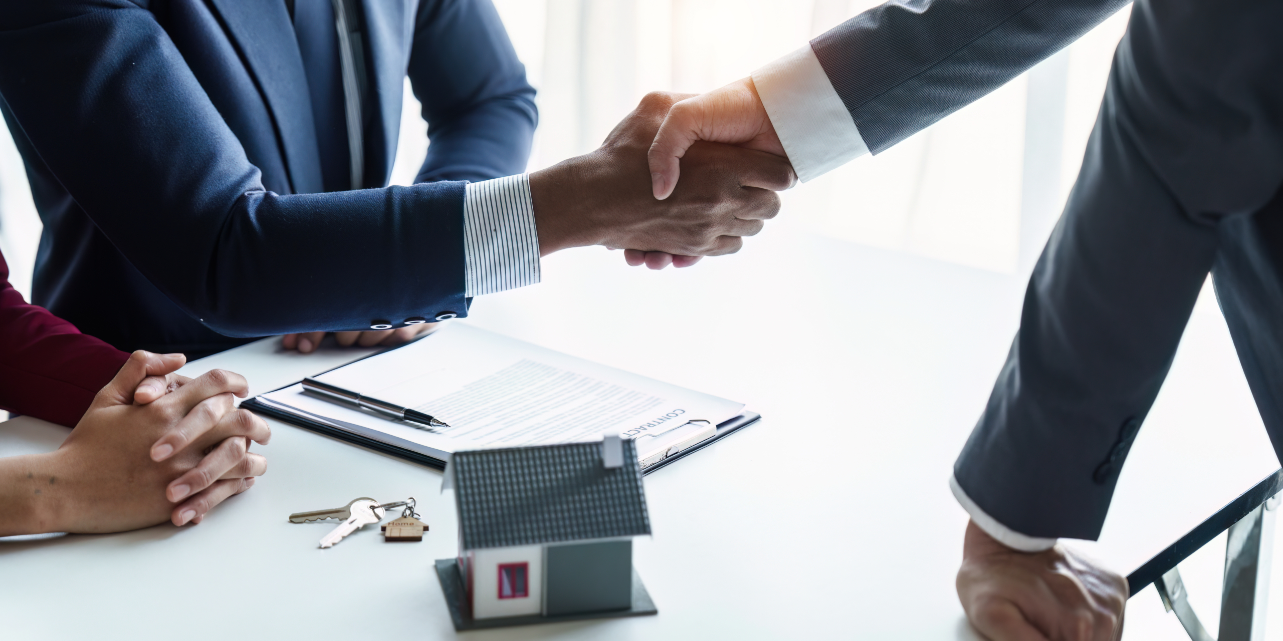 Close up of A businessman buys a house and shakes hands after the transaction.