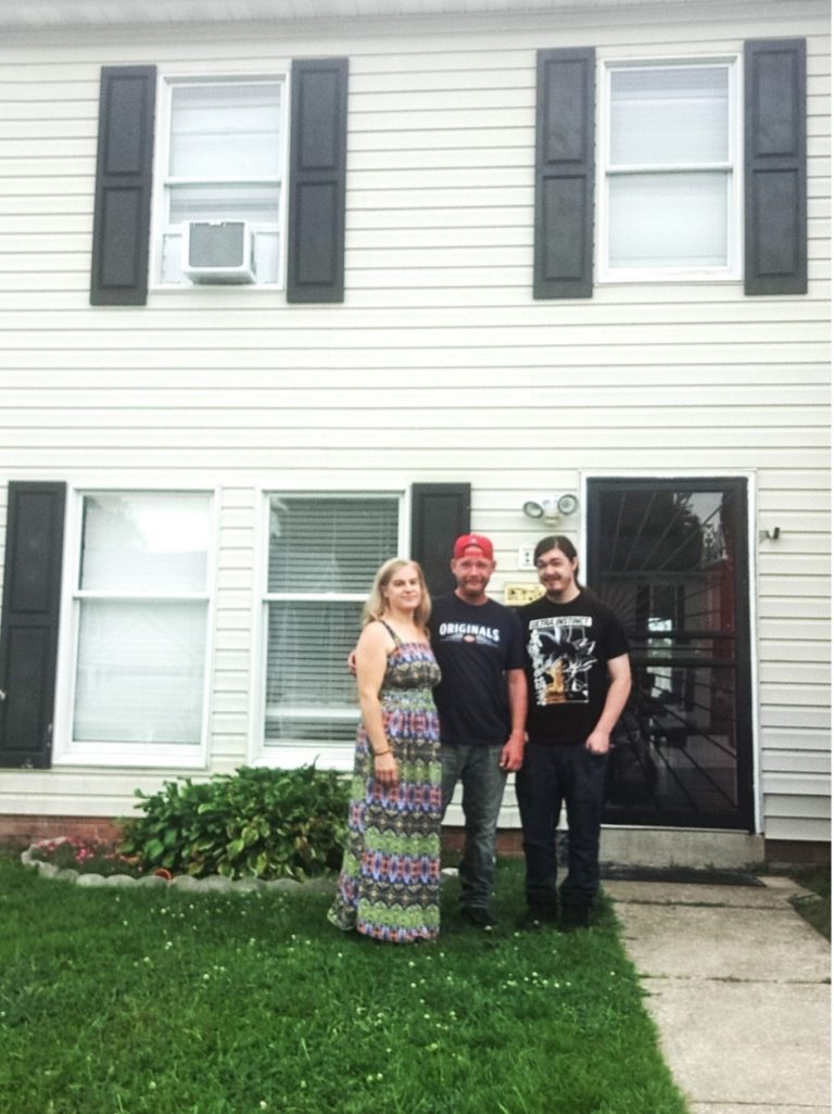 The Lammey family standing in front of their new home.
