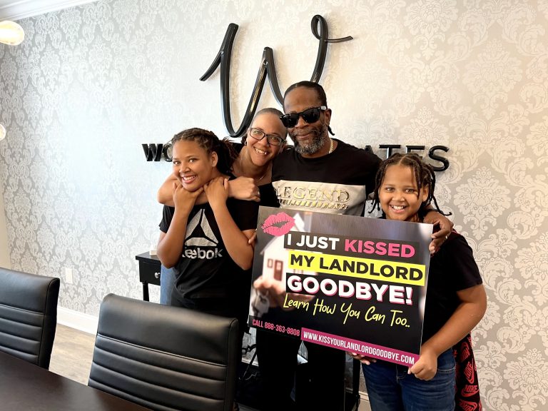 Vickie Day and her family holding a Kiss Your Landlord Goodbye sign in celebration of buying a house.