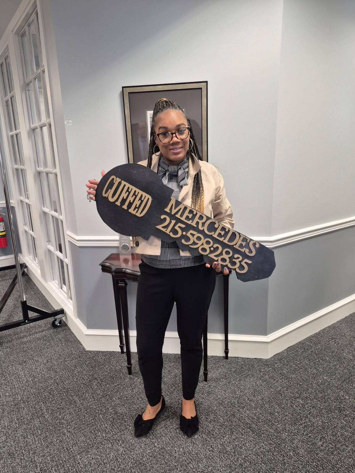 The homebuyer, Alyce Jones, celebrates her new home with a large key sign.