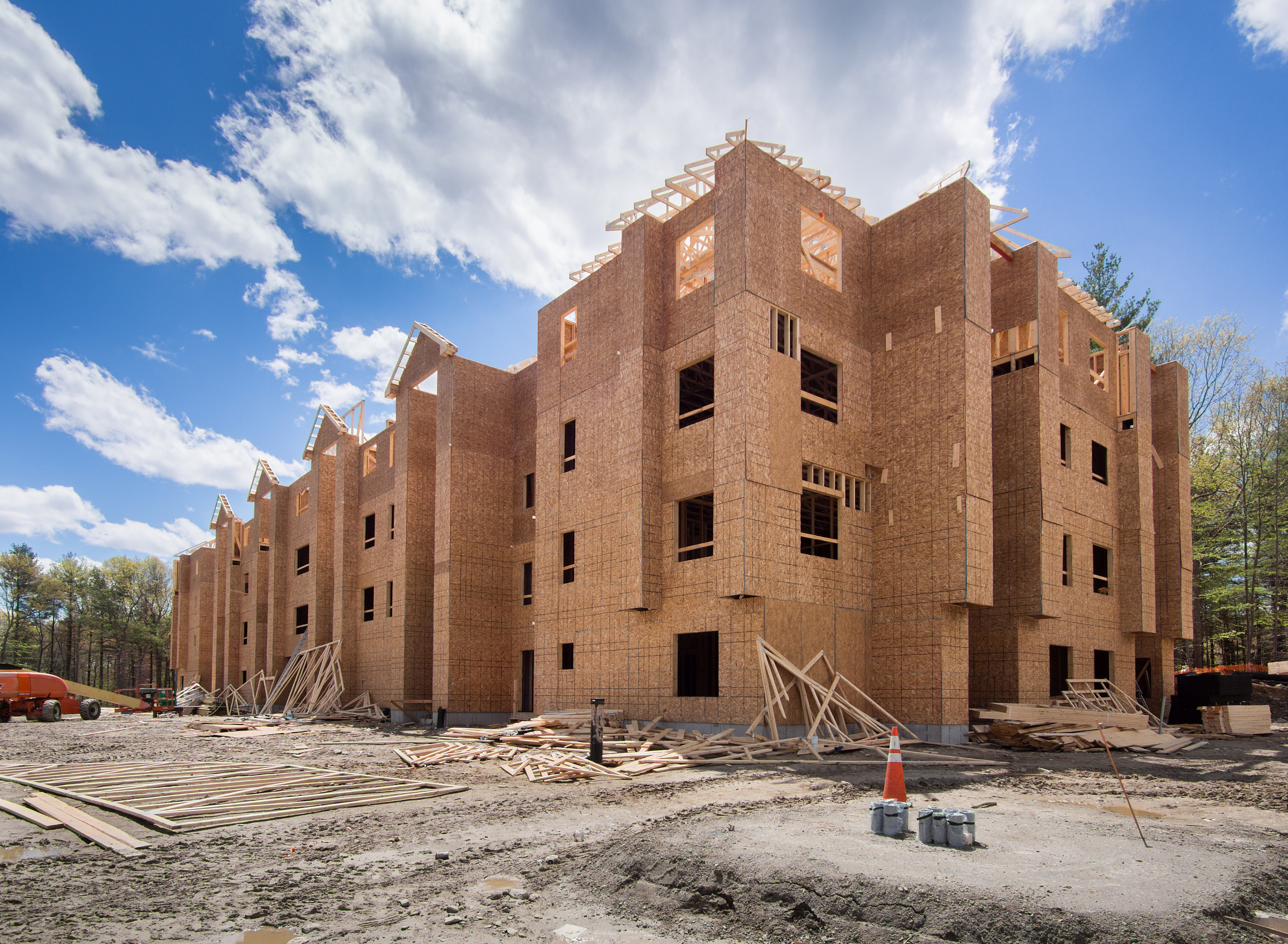 Multistory apartment building under construction with exposed wood framing and sheathing