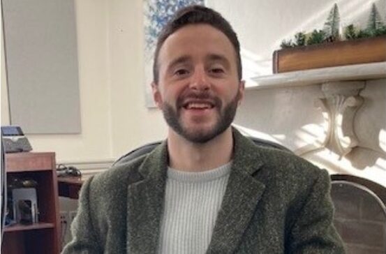 Alex Modeas seated at a desk in DSHA’s offices